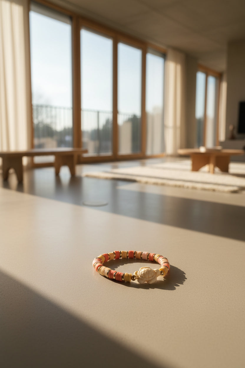 Bracelet with pink, beige, and gold beads on a light gray background