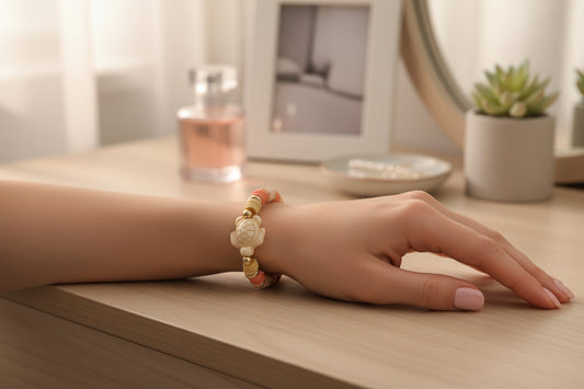 Bracelet with pink, beige, and gold beads featuring a turtle charm on a light gray background